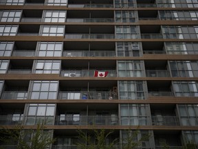 A Canadian flag on the balcony of an apartment building in Toronto.  The city suffers from sanitation shortages and unsustainable house prices.